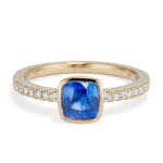 Cushion Cut Blue Sapphire and Diamond Ring. bezel set sapphire and bead set diamond sides. straight on view