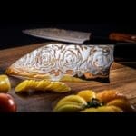 Kultro Flare Chef knife set Rainbow Damascus blades are 34 layers of stainless steel, copper and brass with a Japanese Hitachi Blue Steel core Finished with Cocobolo and black lip pearl handle-in use