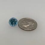 Aquamarine loose with a dime for scale