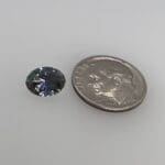 Tanzanite oval loose with a dime for scale