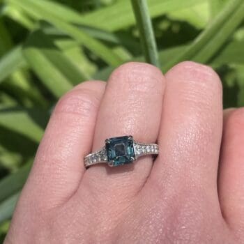 Platinum engagement ring with teal sapphire center and hexagonal diamond side accents, size 6.5