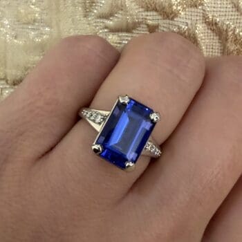 New Horizon ring with deep purple tanzanite center and emerald cut side gemstones set in platinum, size 6.25