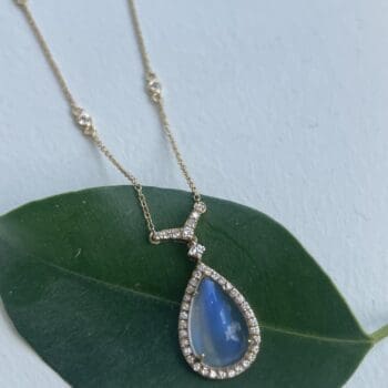 18K yellow gold necklace with a pear cut Blue Rainbow Moonstone and diamond halo on adjustable chain